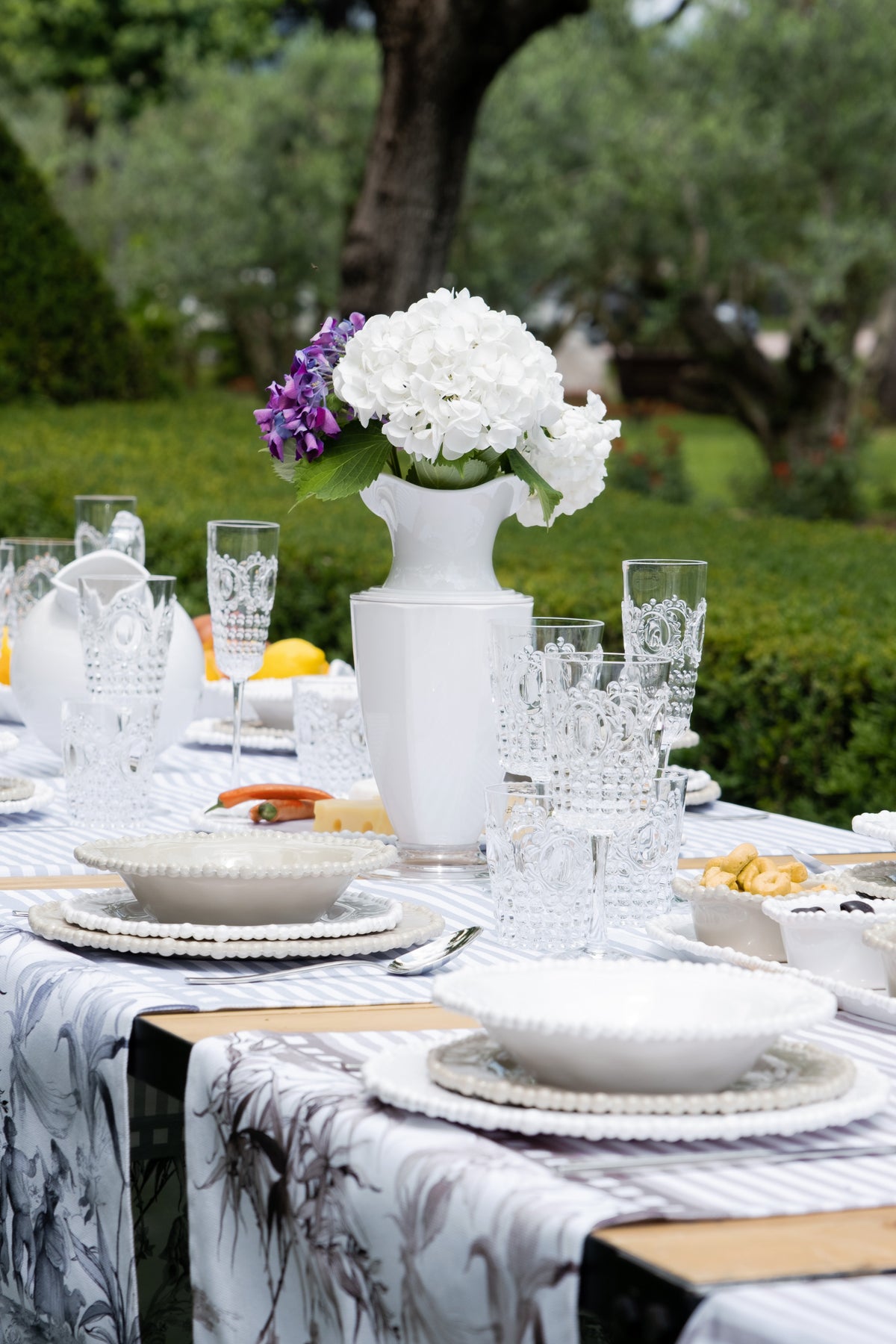 Italian melamine dinnerware set on an outdoor picnic table — Baci Milano Joke collection