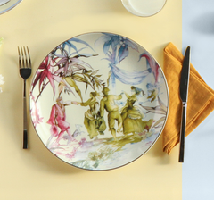 Decorative plate with artistic design of people and nature on a table setting with cutlery and napkin.