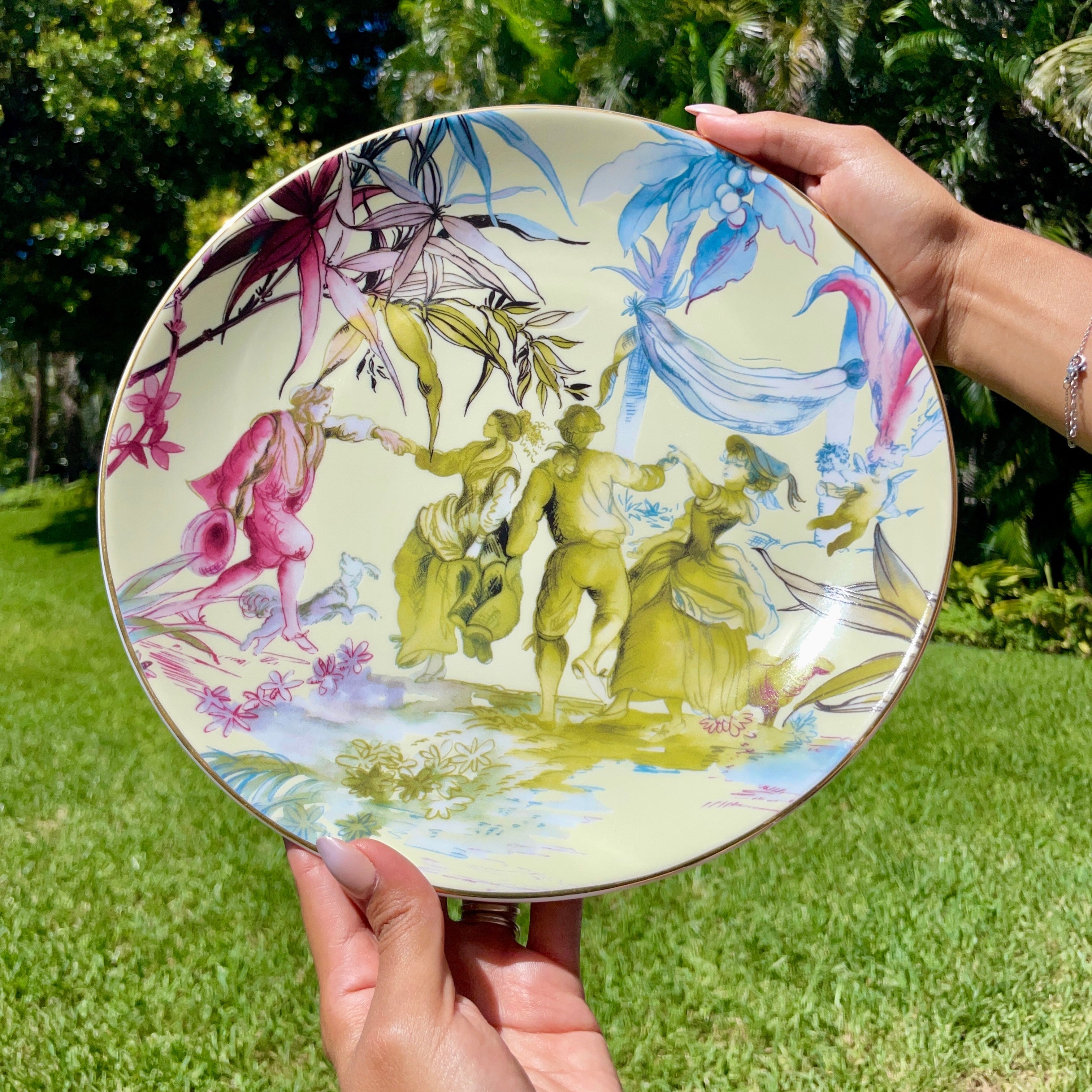Person holding a decorative plate with artistic design outdoors